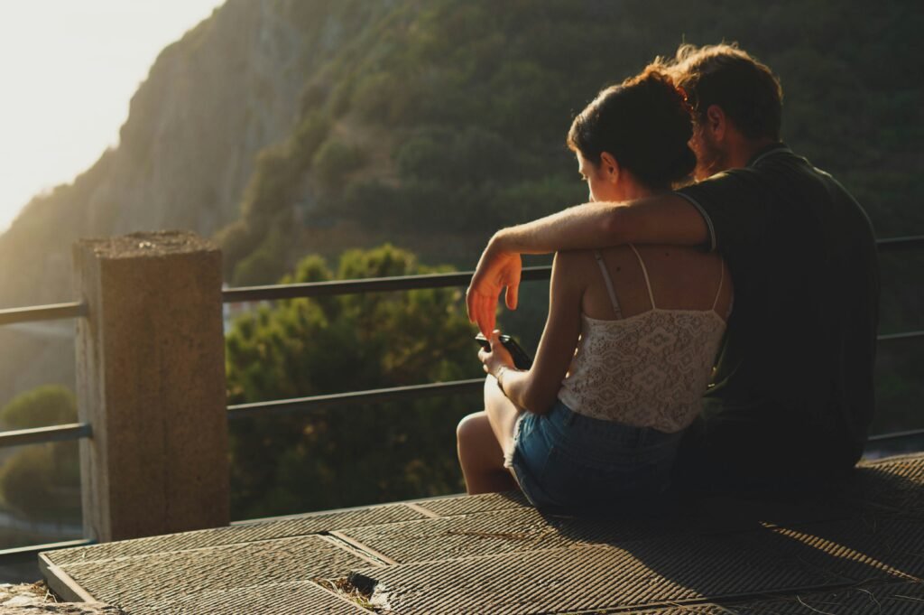man and woman sitting on concrete surface